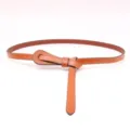 Vue détaillée de ceinture fine en cuir pour femme marron avec nœud élégant et stylé. - Chameau