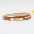 Elegant thin brown patent leather belt with gold metal buckle for women, stylish waist accessory. - Camel