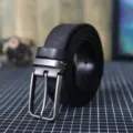 Primo piano dettaglio della cintura in vera pelle nera da uomo con fibbia in metallo. - Nero / 105cm