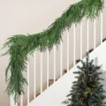 Weelderige kunstmatige Norfolk dennen slinger elegant gedrapeerd over witte houten trappen - 2.7m 13-Tandige Dennen Slinger (116 Takken)