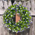 Detailed view of spring wreath with purple and white flowers on rustic wooden fence - 45cm (OPP Bag) / Purple White