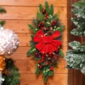 Detailed view of Christmas teardrop swag with red velvet bow and warm LED lights - Scale Pine Swag / With LED Lights