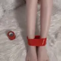 Detail shot showing red electrostatic bondage tape restraining ankles on a soft white fluffy rug. - 16m Width 5cm / Red