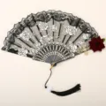 Detailed view of vintage gothic lace folding fan with white rose embroidery and elegant black tassel. - Black Lace Wine Red Rose Fan with Pendant