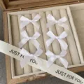 Detailed view of white satin ribbon bows, delicate hair accessories displayed in box - Pure White Bow Hair Clip (Single Piece)