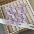 Detail shot of light purple satin ribbon hair bows arranged neatly in a stylish jewelry box. - Light Purple Bow Hair Clip (Single Piece)
