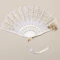 Close-up view of the exquisite white folding fan featuring delicate gold lace embroidery and pendant. - White Sunflower Bronzing Fan with Pendant