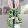 Künstlicher Hasenkranz mit Jutemohren und weißer Blume für die Oster-Haustürdeko. - 45x25x7cm / Osterhase (Rote Ohren)