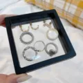Portable jewelry box storage case with mixed fashion rings and clover earrings for travel. - Jewelry Box / Black