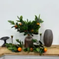 Vista dettagliata di rami di foglie di arancio artificiali in un vaso di ceramica - Ramo d'Arancia / 24 Rami (Con Scatola di Carta)