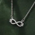 Detail view of a minimalist silver infinity symbol necklace sparkling with cubic zirconia stones. - X5879-2 Style