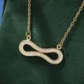 Close-up shot of a gold-plated infinity pendant necklace sparkling with cubic zirconia. - X5877-1 Style / Gold
