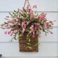 Detail of artificial pink flowers in a rustic woven hanging basket for spring wall decor - 1 Piece / Pink Flower Basket