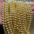 Macro detail of shiny gold electroplated hematite round beads for DIY jewelry making. - 2mm (Approx 190 Pieces) / Electroplated Gold