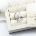 Elegantes Detail eines silbernen geometrischen Rings mit Zirkonia und Perlenfassung. - Überkreuz-Stil / 28.5mm Leere Schale / Silber