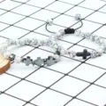 Gedetailleerd overzicht van tweedelige kralen kruis armbanden met 8mm stenen en unieke bedels. - Stijl 6 (Gouden Golfketting)