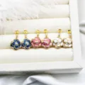 Close-up of floral enamel jewelry components for DIY earrings in white display box. - Camellia Shape (15*25mm) / One Pair / Blue
