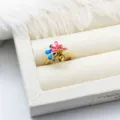 Macro view of gold-plated enamel flower ring setting with pearl mounting and CZ stone - Rose & Blue Flower Style