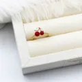 Macro shot of a 18K gold plated cherry ring featuring red enamel and zircon leaves - Small Red Cherry Style