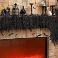 Close-up of black cedar leaf garland used as a spooky Halloween fireplace decoration. - 1.8m 48 Heads / Black