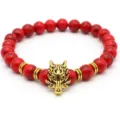Dettaglio del bracciale di perle rosse con ciondolo a testa di lupo dorato e anelli distanziatori. - Testa di Lupo Oro / Rosso