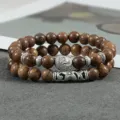 Detail van de dubbele houten kralen armband met boeddha hoofd hanger en decorative metalen elementen. - Kleur 5