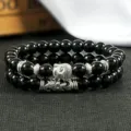 Close-up detailopname van dubbele zwarte kralen armbanden met zilveren Boeddha bedel. - Kleur 10
