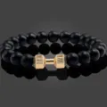 Gedetailleerd overzicht van de zwarte kralenarmband met gouden dumbbell fitness bedel. - Obsidiaan