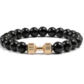 Detailopname van zwarte kralenarmband met gouden dumbbell hanger, fitness sieraden. - Obsidiaan