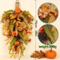 Macro view of artificial pumpkin and pinecone detail on fall teardrop door swag decoration. - Autumn Pumpkin Swag