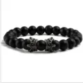 Vue rapprochée détaillée du bracelet en perles mates noires avec charmes couronne argent. - Noir Mat