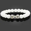 Witte kralen yoga fitness armband detail met zilveren halter bedel en gravure. - Wit