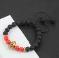 Gedetailleerd overzicht van 8mm lavasteen yoga armband met rode agaat kralen en helm. - 6