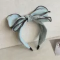 Elegant mint blue oversized bow headband with brown contrast piping for a classic chic look - Light Blue