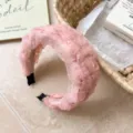 Diadema ancha trenzada de malla rosa con textura delicata en entorno de estilo estético. - Rosa
