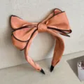 Elegant apricot fabric bow headband with black piping for high skull top styling - Rose Pink