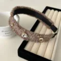 Elegant brown knitted headband with sparkling rhinestones and gold studs on display - Brown