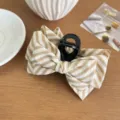 Elegante pinza para el pelo con un lazo grande de tela a rayas en crema y beige - Caqui