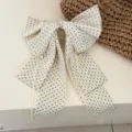Elegant cream hair claw clip featuring black polka dot bow and long ribbon streamers - Satin Polka Dot Cream White