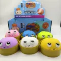 Six colorful squishy baozi fidget toys with big eyes sitting in gold steamer baskets - Big-eyed Bun Style