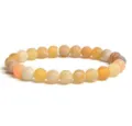 Close up of frosted weathered agate beaded bracelet showing crackled texture and warm tones. - Yellow