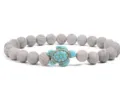 Beaded bracelet featuring gray textured stone beads and a charming blue turquoise turtle pendant. - Gray