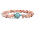 Detail shot of pink marbled gemstone beaded bracelet featuring a cute turquoise turtle charm. - Pink