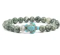 Close-up detail of the green stone bead bracelet featuring a turquoise turtle charm centerpiece. - Green