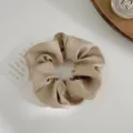 Close-up detail of champagne scrunchie with sparkling rhinestone embellishments - Khaki