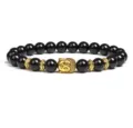 Closeup detail of 8mm black stone bead bracelet featuring a golden Buddha head and spacers. - Black Bead