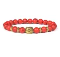 Detailed shot of red stone beaded bracelet with golden Buddha head and metal spacers. - Red Cracked Stone
