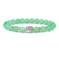 Detailed close-up of green stone bead bracelet featuring a carved buddha head and silver spacers. - Green Semi-precious Stone