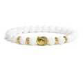 White bead bracelet detail featuring a golden Buddha head charm and stylish metal spacers. - Agate