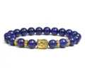 Closeup detail of blue lapis lazuli beaded bracelet with gold Buddha head charm and spacers. - Lapis Lazuli